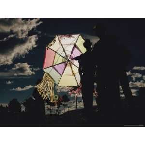 Several Men Hold a Kite That is Backlit by the Sun Photographers 