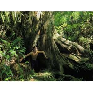  A Shirtless Man Emerges from the Hollow Trunk of a Tree 