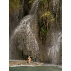  A Woman Sits in the Cool of a Grotto by a Waterfall 