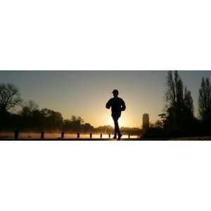  Jogger Silhouetted Against the Rising Sun as He Runs Past 